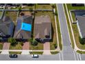 Aerial view showcasing the property's roof, well-kept lawn, landscaping, and brick driveway at 1720 Reflection Ln, St Cloud, FL 34771