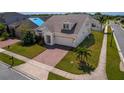 Well-maintained home featuring a two-car garage, brick driveway, neat landscaping, and a healthy young palm tree at 1720 Reflection Ln, St Cloud, FL 34771