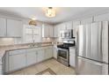 Bright kitchen with stainless steel appliances, white cabinets, granite countertops, and tile flooring at 1139 Santa Cruz Dr, The Villages, FL 32162