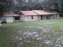 Exterior side view of ranch home and attached building with covered walkway at 3 Lakeside Dr, Ocala, FL 34482