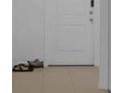 A clean, tiled entryway featuring a white door and shoes in the foreground at 744 Osprey Roost Dr, Lakeland, FL 33801