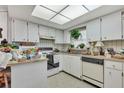 Compact kitchen featuring bright cabinetry, laminate countertops, and a skylight at 159 Sweetgum Ln, Port Orange, FL 32129