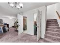 Spacious living room featuring carpet floors, adjacent bathroom, and stairs to upper level at 159 Sweetgum Ln, Port Orange, FL 32129