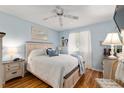 Comfortable bedroom with a queen-size bed, wood floors, and soft blue walls creating a relaxing atmosphere at 11540 Sw 84Th Avenue Rd, Ocala, FL 34481