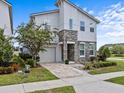 Charming two-story home features a stone facade, manicured lawn, paver driveway, and attached garage at 9001 Flamingo Key Way, Kissimmee, FL 34747
