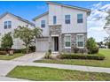 Charming two-story home features a stone facade, manicured lawn, paver driveway, and attached garage at 9001 Flamingo Key Way, Kissimmee, FL 34747
