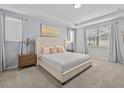 The bright primary bedroom features a tray ceiling, large windows, carpet, and an upholstered headboard at 9001 Flamingo Key Way, Kissimmee, FL 34747