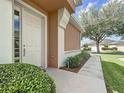 Home exterior featuring front door, well-kept landscaping, and a tidy sidewalk leading to the entrance at 9582 Sw 70Th Loop, Ocala, FL 34481