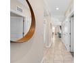 Bright hallway with tile flooring, multiple doors, and an elegant circular mirror on the wall at 3120 Paradox Cir # 307, Kissimmee, FL 34746