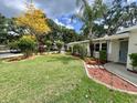 Beautiful front yard featuring lush green lawn, trees and landscaping at 3610 Pershing Ave, Orlando, FL 32812