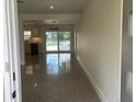 Open-concept living room with terrazzo flooring, and sliding glass doors leading to the outdoor space at 3610 Pershing Ave, Orlando, FL 32812