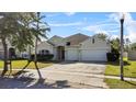 Inviting single-story home featuring an arched doorway, a two-car garage, and front yard at 3657 Daydream Pl, St Cloud, FL 34772