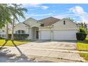 Well-kept single-story house featuring a two-car garage, arched entryway, and driveway at 3657 Daydream Pl, St Cloud, FL 34772