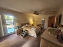 Cozy main bedroom with ceiling fan, carpet floors, and pool view from the large window at 738 Adidas Rd, Winter Springs, FL 32708