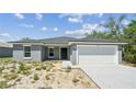 A simple single-story home with an attached garage and a freshly painted exterior at 1204 Alafia Way, Kissimmee, FL 34759