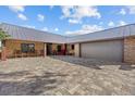 Ranch home showcasing brick accents, a two car garage, and a beautiful brick paved driveway at 6820 County Road 561, Clermont, FL 34714