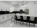 Modern kitchen with white cabinets, stainless steel appliances, and a spacious island with barstool seating at 8456 Se 164Th Pl, Summerfield, FL 34491