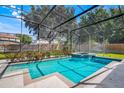 Relaxing screened-in pool and spa with a waterfall feature surrounded by lush landscaping at 1125 English Garden Ln, Winter Garden, FL 34787