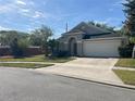 Beautiful single-story home boasts a two-car garage and a well-kept lawn framed by mature trees and shrubs at 10930 Buckwater Ct, Orlando, FL 32817