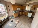 Kitchen featuring tile floors, wooden cabinets, and essential appliances at 13026 Baltimore Woods Ln, Orlando, FL 32824