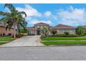 Charming single-story home with a neatly maintained lawn, colorful landscaping, and a spacious driveway leading to the entrance at 508 Bacio St, New Smyrna Beach, FL 32168