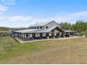 Beautiful farmhouse with a long covered porch sits on a spacious grassy lot at 11657 Moore Rd, Lakeland, FL 33809