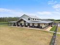 Unique farmhouse on acreage features an expansive covered porch and metal roof at 11657 Moore Rd, Lakeland, FL 33809
