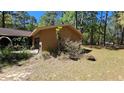 Side exterior view of house with an attached garage and natural surroundings at 20045 Sw 88Th Place Rd, Dunnellon, FL 34431