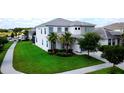 Well-maintained front yard with lush green grass, palm trees, and charming exterior of the two-story home at 4500 Monado Dr, Kissimmee, FL 34746