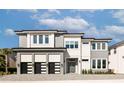 Contemporary two-story home showcasing a three-car garage, light-colored stone facade, and inviting front entrance at 1514 Corolla Ct, Reunion, FL 34747