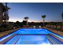 Resort-style pool with water features, a sunning spa, comfortable lounge seating, and lush landscaping at 1514 Corolla Ct, Reunion, FL 34747