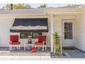 Inviting front porch with comfortable rocking chairs, a small table, and decorative plants enhancing the home's curb appeal at 2382 Due West Dr, The Villages, FL 32162