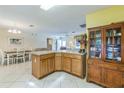 Open kitchen with tile flooring, wood cabinetry, and a functional center island perfect for meal preparation and casual dining at 2382 Due West Dr, The Villages, FL 32162