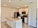 Well-equipped kitchen with stainless steel appliances, granite counters and white cabinets at 5216 Greenheart Ave, Mount Dora, FL 32757