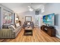 Cozy living room features vaulted ceiling, wood floors, neutral paint, and large windows for natural light at 5003 Timber Ridge Trl, Ocoee, FL 34761