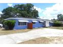 Single-story home with concrete driveway and awning covered windows at 902 S Scenic Hwy, Lake Wales, FL 33853