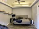 Bedroom with gray walls, tray ceiling, and shelves above bed at 246 Ridge Manor Dr, Lake Wales, FL 33853