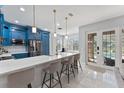 Modern kitchen featuring blue cabinets, a large island with seating, and stainless steel appliances at 13532 Meadow Bay Loop, Orlando, FL 32824
