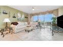 Relaxing living room showcasing a comfy white sectional, tile flooring, and balcony access at 4 Oceans West Blvd # 502B, Daytona Beach, FL 32118