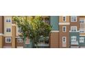 Multi-story exterior with brown and green facade, showcasing architectural interest and a large shade tree at 8749 The Esplanade # 6, Orlando, FL 32836