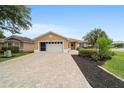 Inviting single-story home with a brick driveway and lush landscaping at 8166 Sw 80Th Ter, Ocala, FL 34476