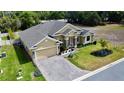 Aerial view of the home, featuring the manicured lawn, the driveway, and the lovely landscaping at 1568 Cordgrass Way, Lakeland, FL 33813