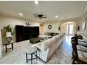 Spacious living room with tile floors, a ceiling fan, and comfortable sectional seating at 1568 Cordgrass Way, Lakeland, FL 33813