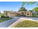 Single-story house with a light-colored exterior, tidy landscaping, and an attached garage at 2899 Sw 66 St, Ocala, FL 34476