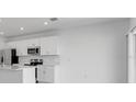 Bright kitchen featuring white cabinetry, stainless appliances, an island with sink, and natural light at 5133 Forget Me Not Ave, Lake Hamilton, FL 33851