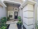 Inviting front entrance with a decorative door, sidelight window, and manicured landscaping at 3905 Westerham Dr, Clermont, FL 34711