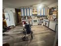 Bright kitchen with painted cabinets, white appliances, and newer vinyl floors at 725 6Th Ne St, Fort Meade, FL 33841