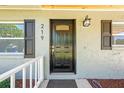 Close-up of the front door, accented by stylish shutters and a modern exterior light fixture at 219 Vermont Ave, St Cloud, FL 34769