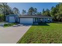 Well-kept home with long driveway, green lawn and additional building with ample parking at 9085 Sw 202Nd Avenue Rd, Dunnellon, FL 34431