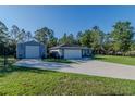 Charming home featuring an extra building, beautiful lawn, and long driveway at 9085 Sw 202Nd Avenue Rd, Dunnellon, FL 34431